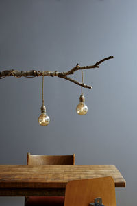 Low angle view of electric lamp hanging on wood