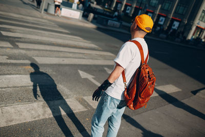 Rear view of man walking on road