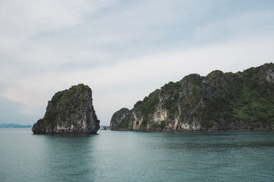 Rock formations in sea against sky