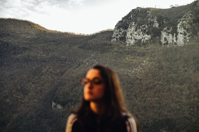 Portrait of young woman standing on mountain