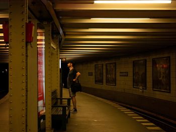 Side view of man standing on subway station