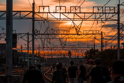 Rear view of people walking at sunset