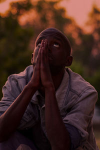 Portrait of young man sitting on field