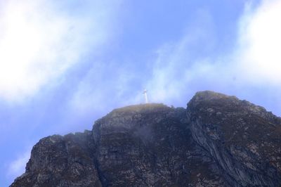 Low angle view of bird on mountain against sky