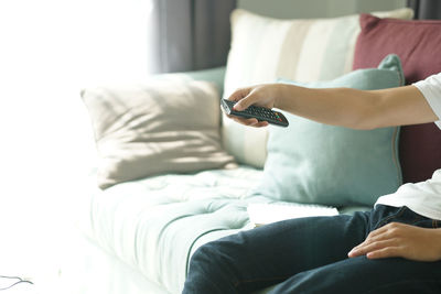 Midsection of man using laptop on bed