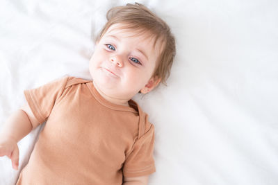 Happy cute baby girl lying on bed