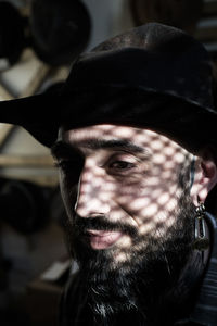 Close-up of man wearing hat looking away