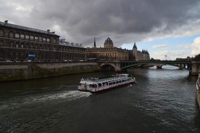 Bridge over river against cloudy sky