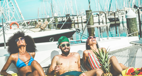 Friends relaxing at beach in sunny day