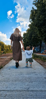 Rear view of woman walking on footpath