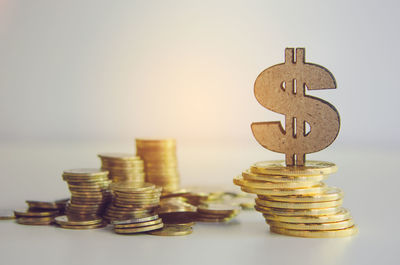 Close-up of dollar sign on stacked coins over table