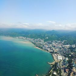 High angle view of city by sea against sky