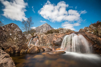 Scenic view of waterfall against sky