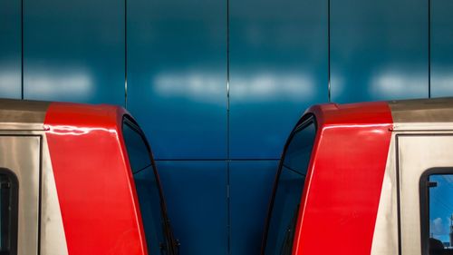 Close-up of red railing against blue wall