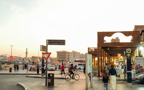 People on street in city against sky