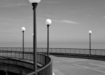 Lights by highway against sky