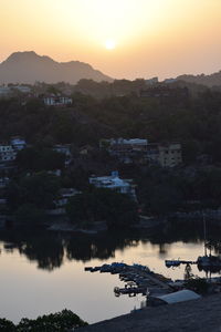 High angle view of townscape by river against sky during sunset