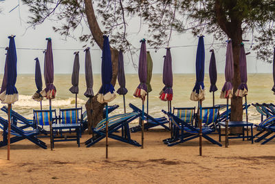 Chairs on beach against sky