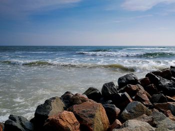 Scenic view of rocks on beach against sky