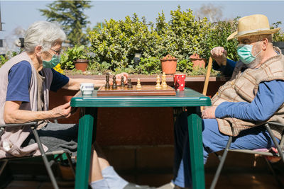 People relaxing on table by chairs