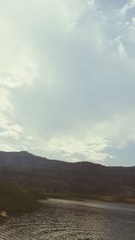 Scenic view of mountains against cloudy sky
