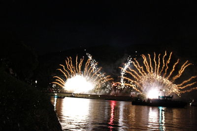 Illuminated bridge over river at night