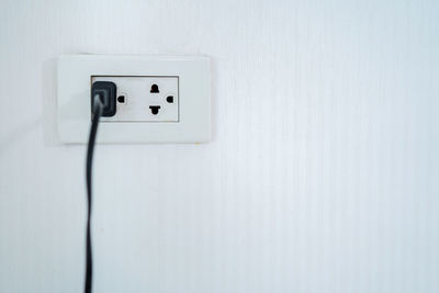 Close-up of electric lamp on wall at home