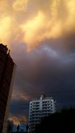 Low angle view of buildings against cloudy sky