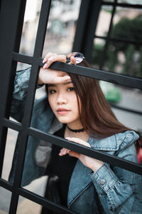 Portrait of woman standing by telephone booth