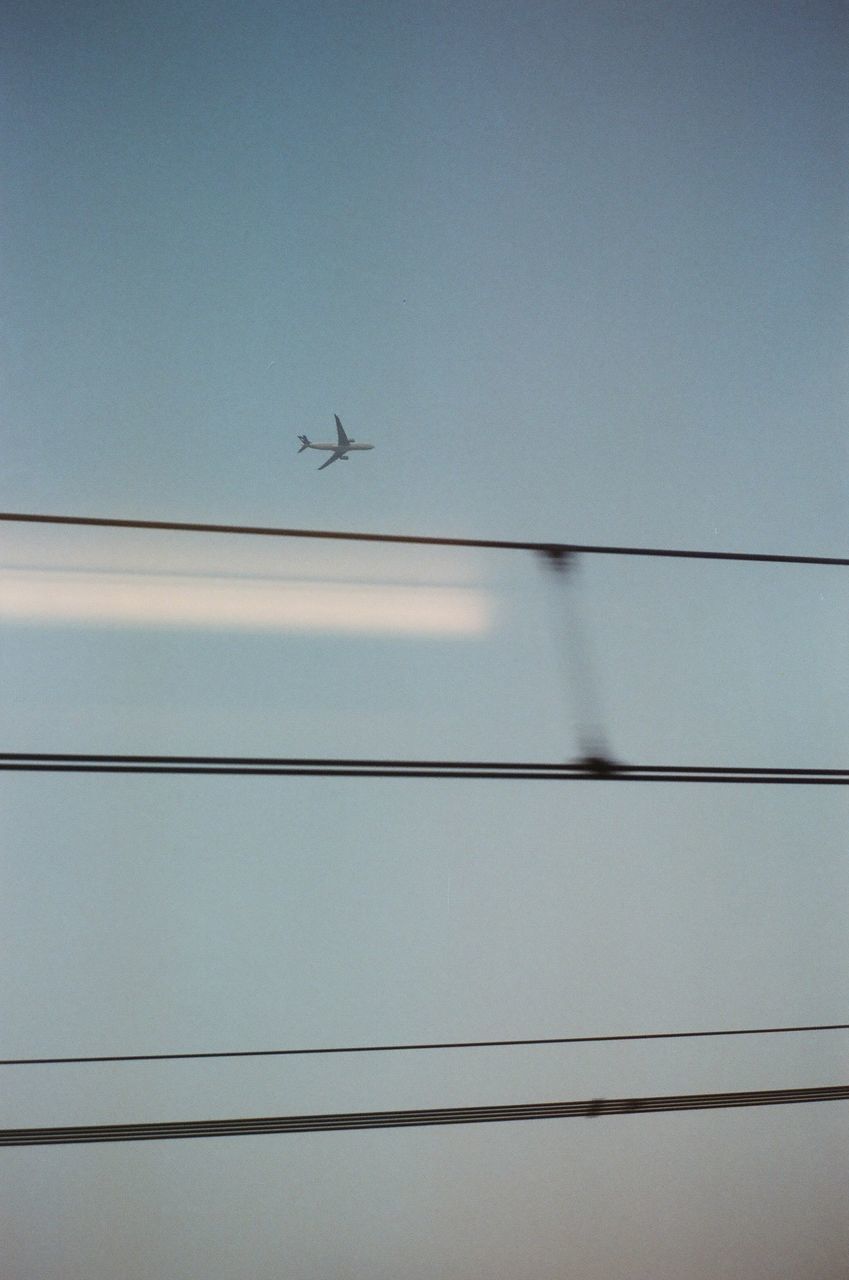 LOW ANGLE VIEW OF AIRPLANE FLYING AGAINST THE SKY