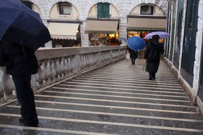 Rear view of people walking on steps in city