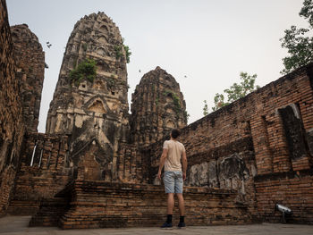 Rear view of a man standing in front of temple, sukhothai, thailand