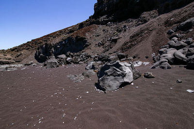 Rock formation on beach against sky