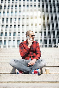 Full length of young man sitting outdoors