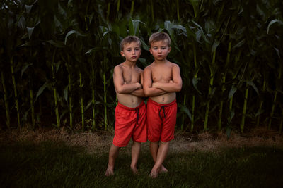 Portrait of shirtless boy standing outdoors