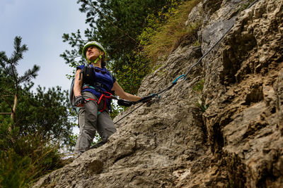Low angle view of woman climbing on mountain