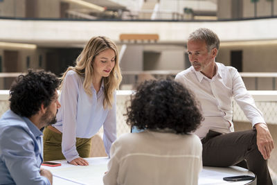 Multiracial business colleagues discussing strategy over document in meeting