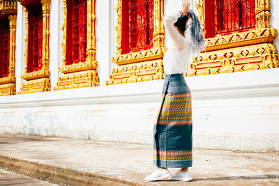 Rear view of woman walking in temple against building