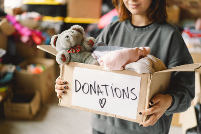 Volunteer teengirl preparing donation boxes for people.