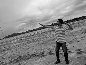 Full length of man standing on beach against sky