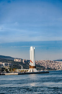 Sea by buildings against sky in city