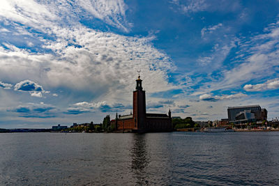 View of building by lake against sky