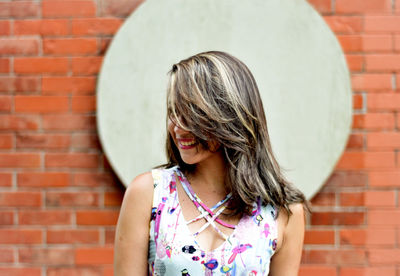 Woman standing against brick wall