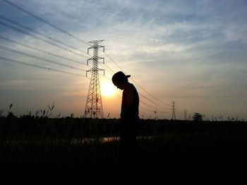 Low angle view of silhouette man standing on field against sky