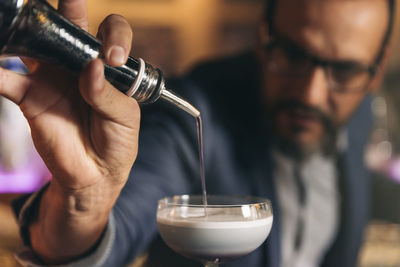 Male bartender preparing cocktail at bar counter