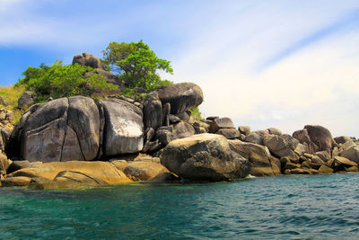 Rocks on sea shore against sky