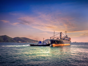 Ship moored on sea against sky during sunset