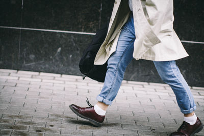 Low section of man walking on sidewalk