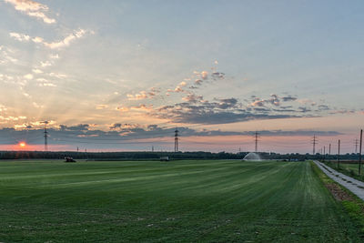 Scenic view of grassy landscape against sky during sunset