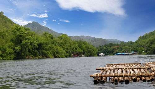 Scenic view of river by trees against sky